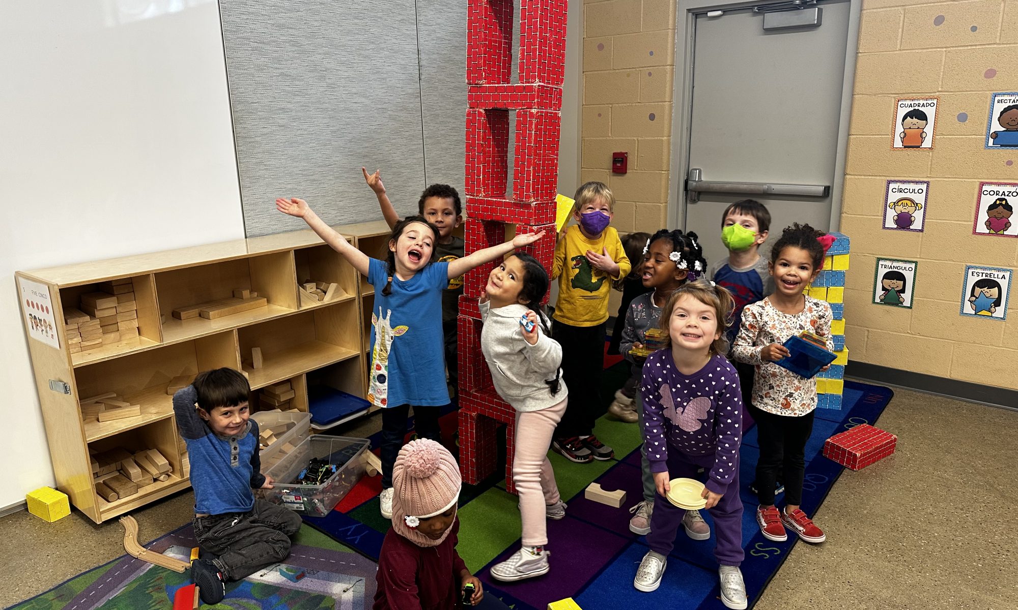 preschoolers pose with block tower