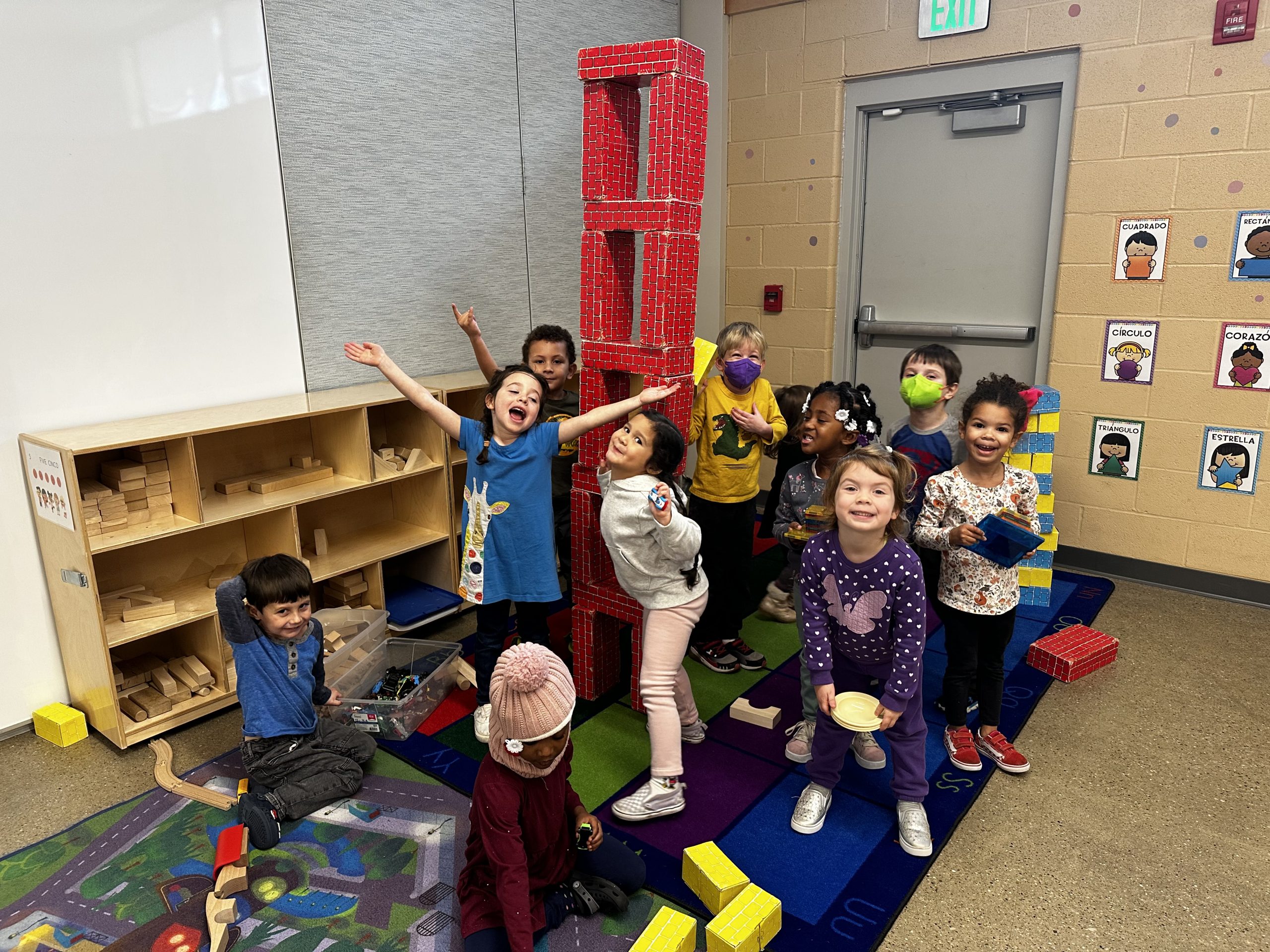 preschoolers pose with block tower