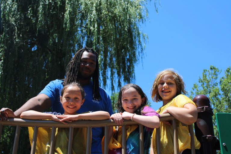 Camp supervisor hangs out with kids on the playground