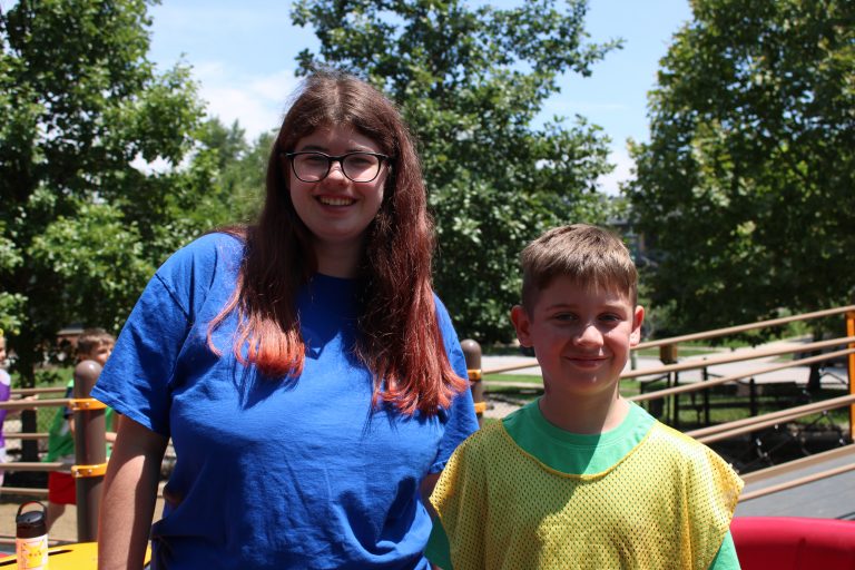 Camp counselor poses with camper