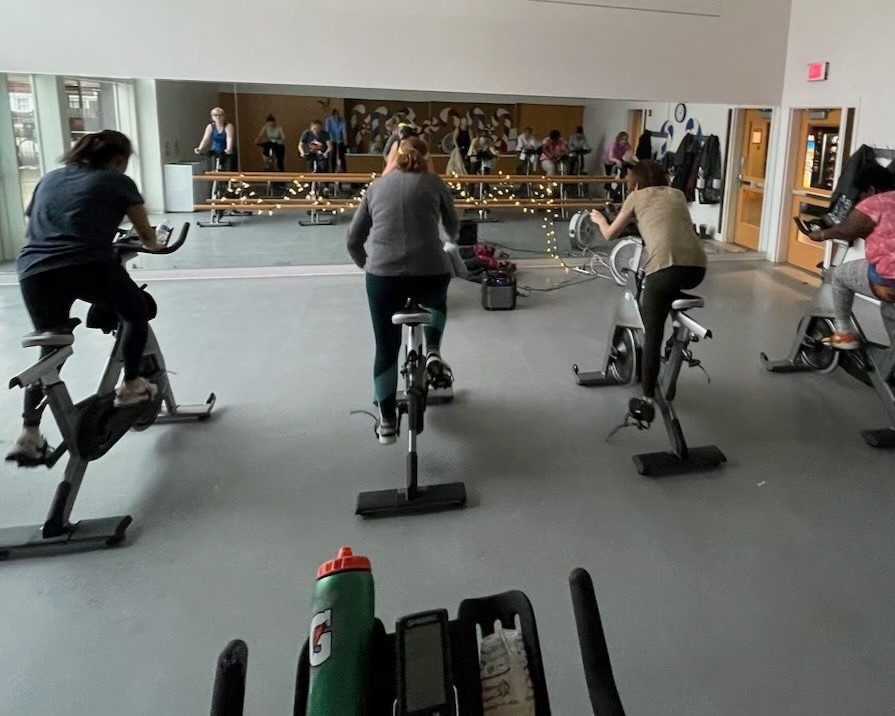 cycle class participants pedal on their bikes