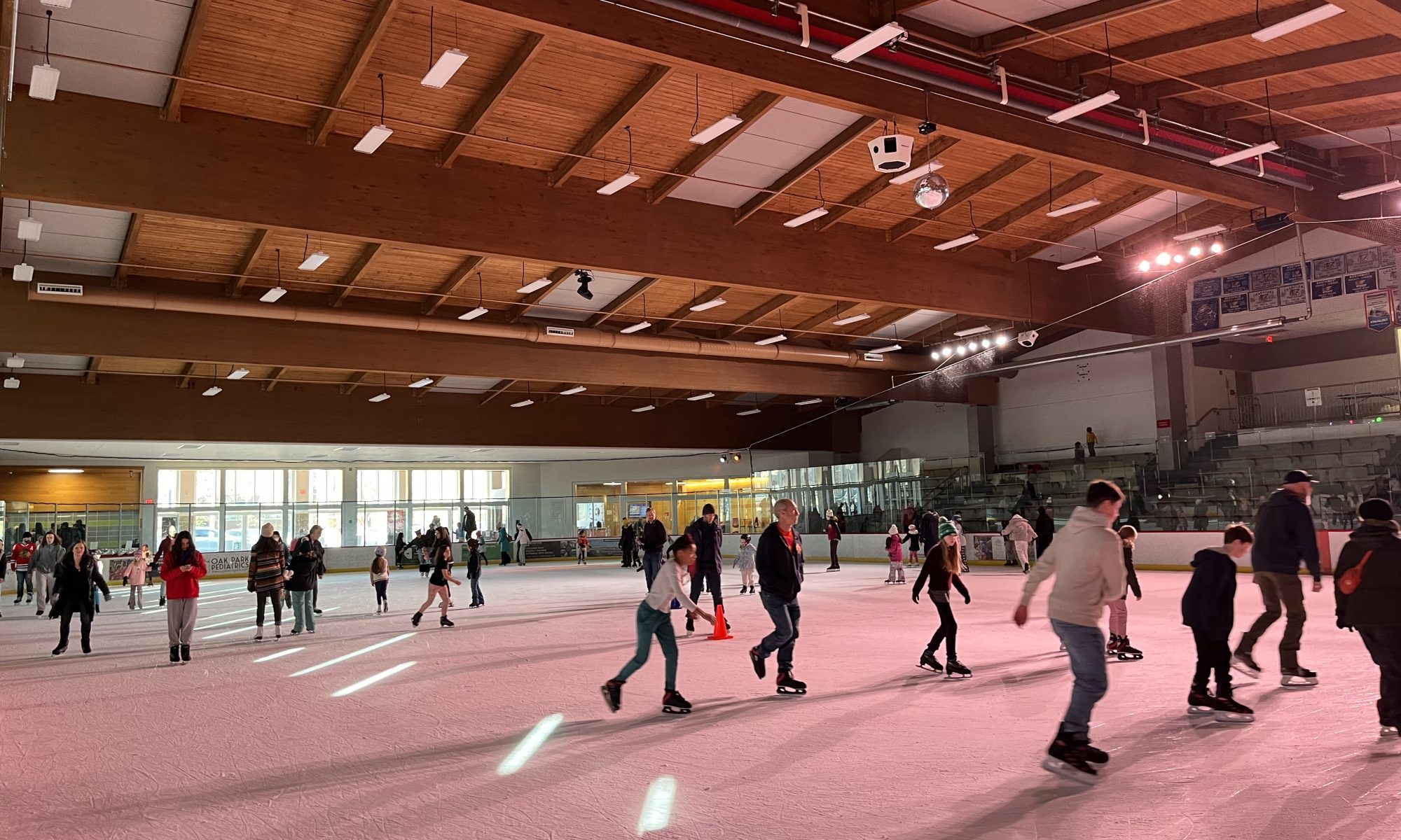skaters at the rink under pink lights