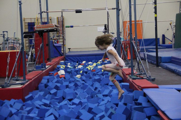 a girl jumps into the foam pit