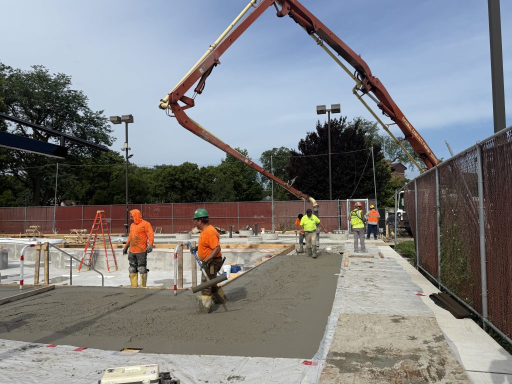 large concrete arm hovers above pool shell