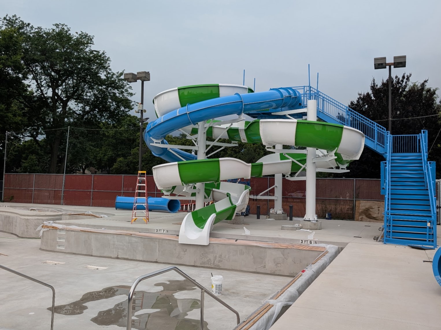 blue tube slide and green and white open slide at rehm pool
