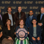 park district board and staff members hold gold medal grand plaque