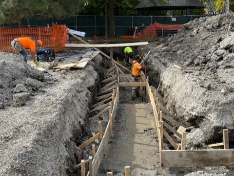 deep channel is cut through the dirt with wood framing on either side