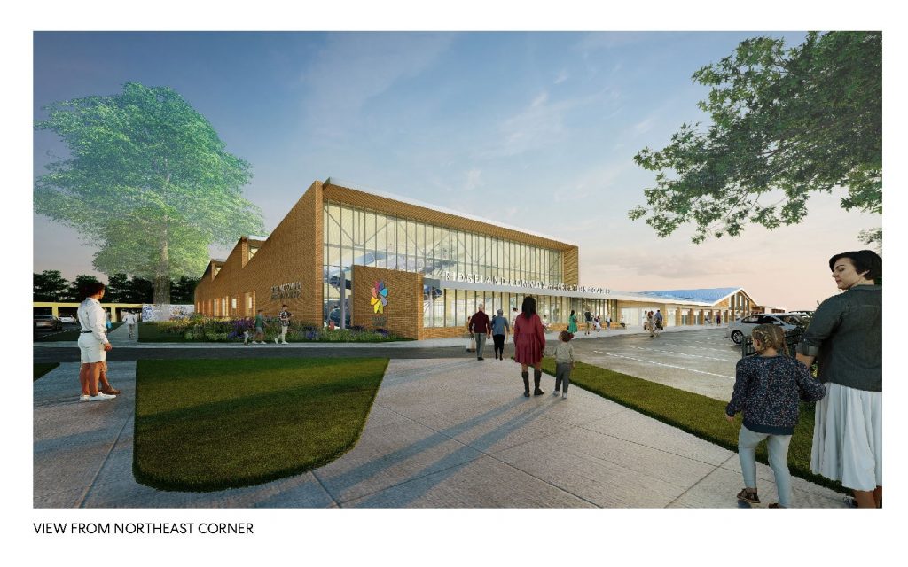 large brick building with floor to ceiling windows showing a waterslide, captioned view from northeast corner