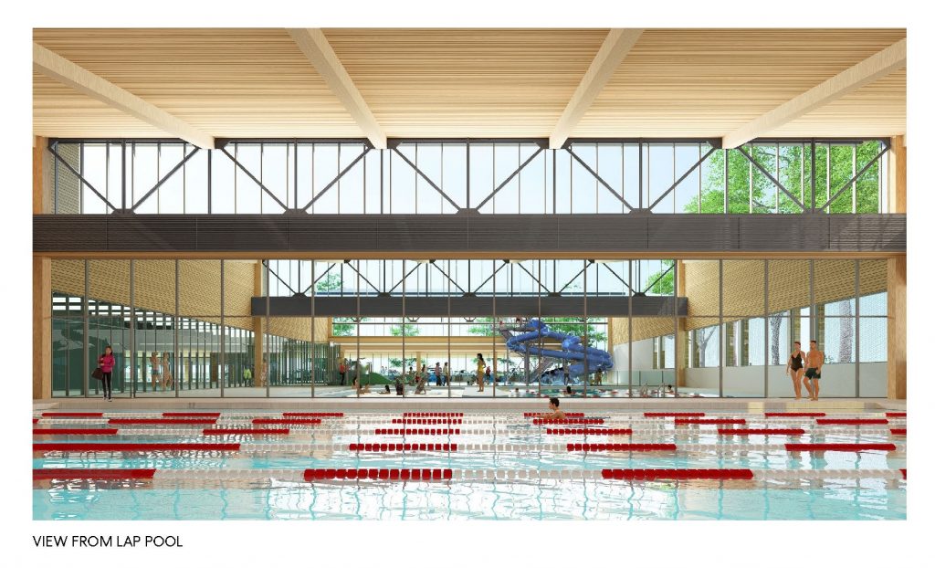 lap pool with clear divider in background showing additional pools and waterslides captioned view from lap pool