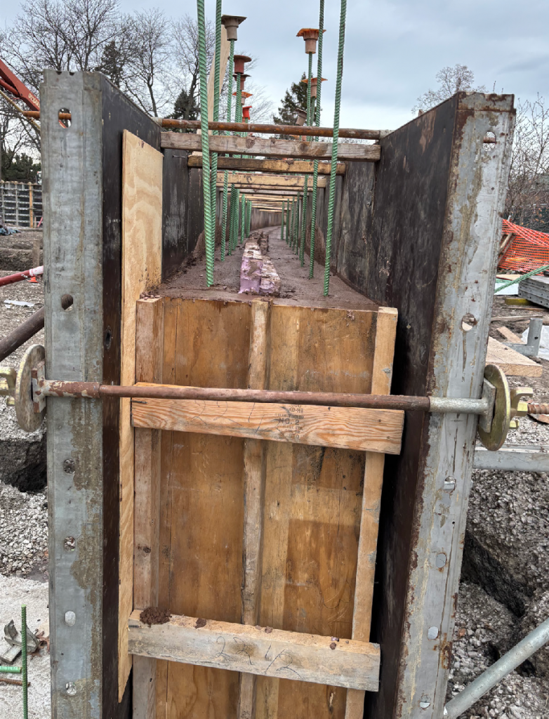side view of foundation forms with concrete poured in