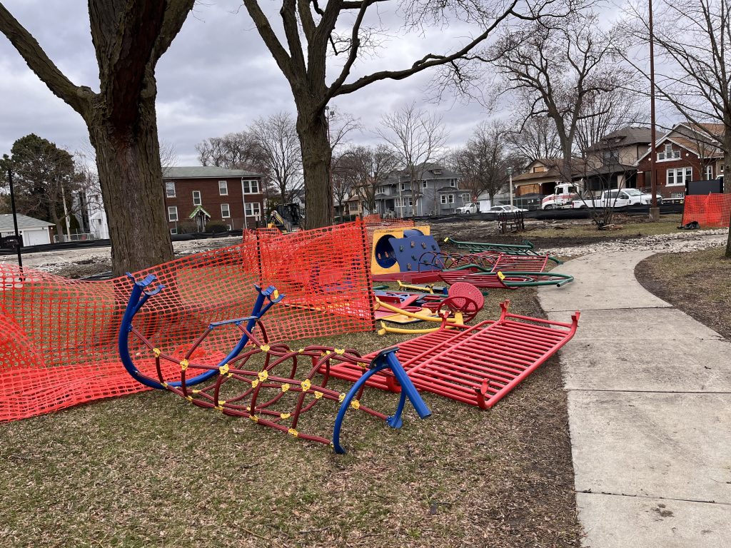 disassembled playground equipment laying in the grass