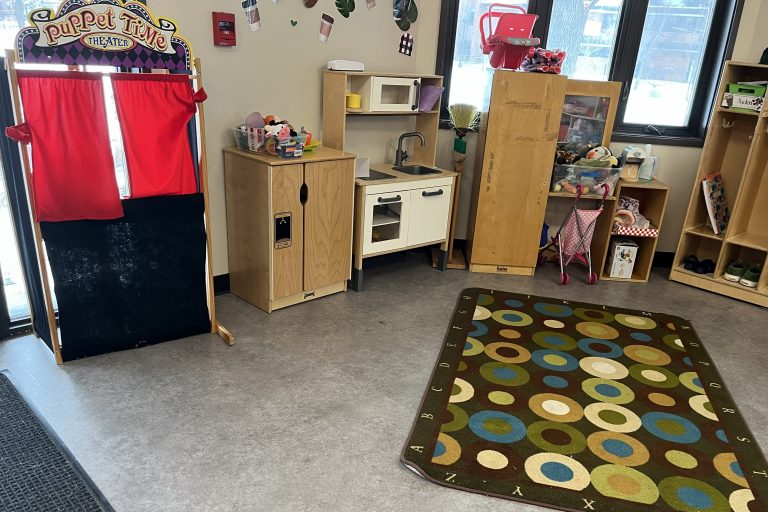 a group of toys including a puppet stage and play kitchen