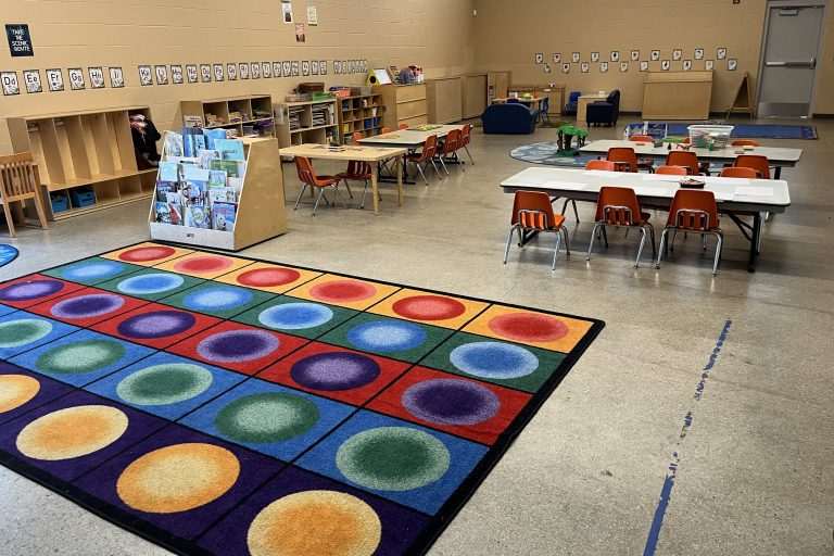 a large rug for sitting with tables and low chairs in the background