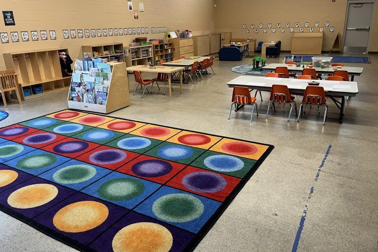 a large rug for sitting with tables and low chairs in the background