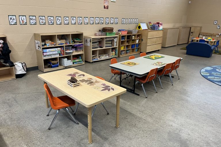 two tables with cubbies in the background and the ABCs on the wall