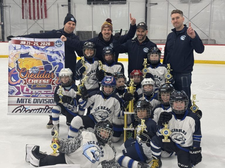 ice bears in white jerseys hold three tier trophy and smile