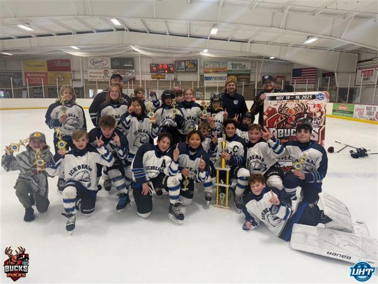 ice bears pose around a trophy and banner