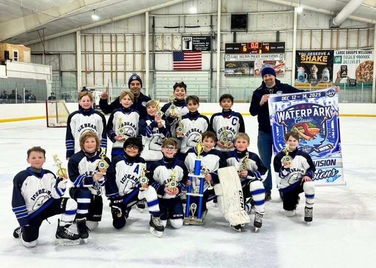 Ice bears team holds up banner that says Waterpark Classic Champs