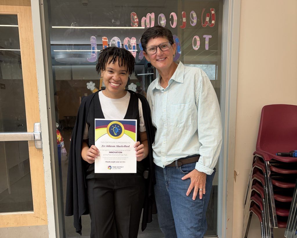 a counselor holds up their certificate while posing for a photo with the executive director